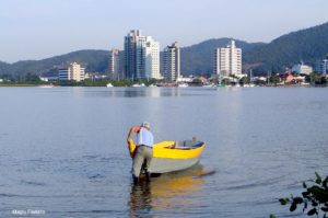 Homem tirando barco da água no saco da fazenda